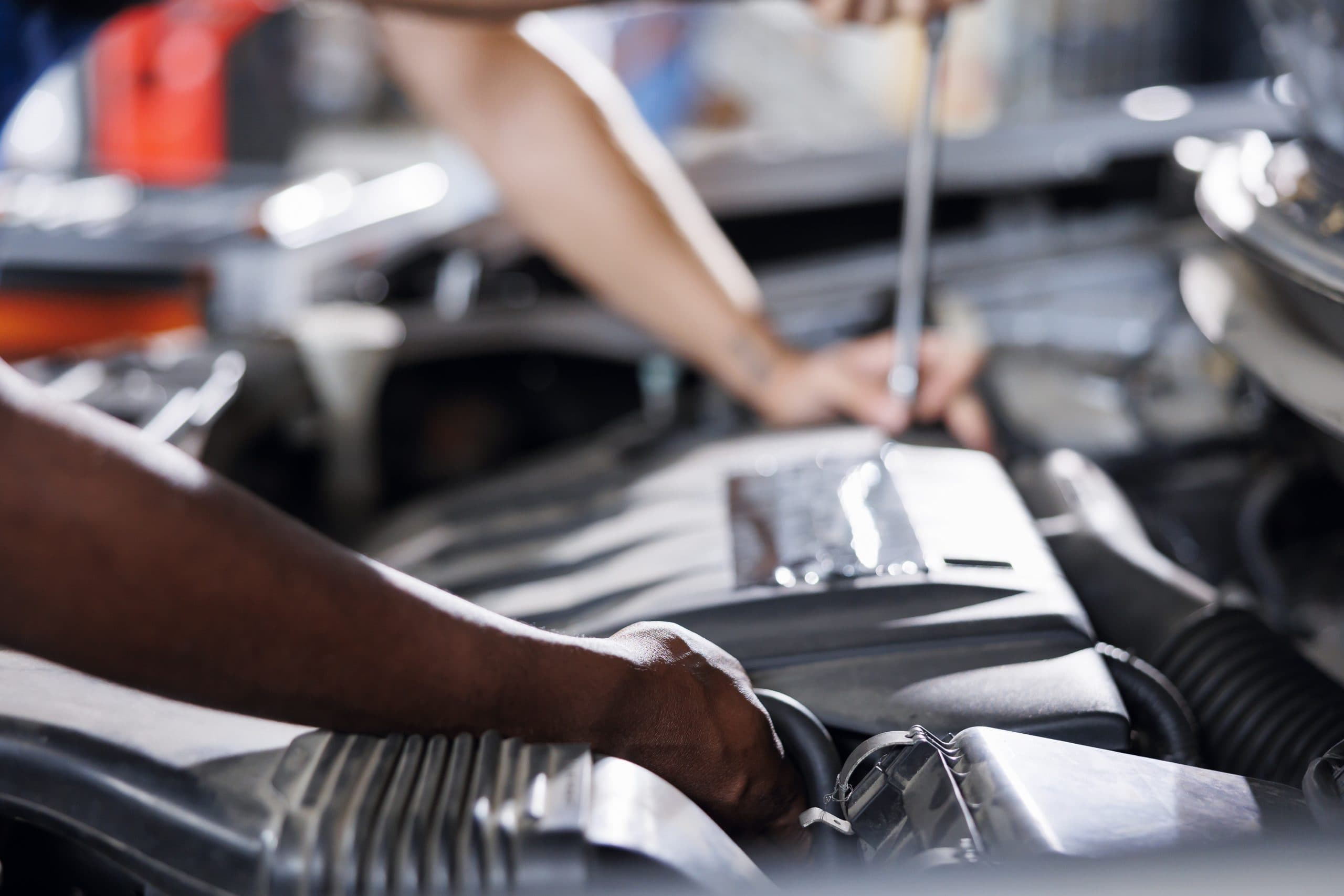 Total Car Care technician using diagnostic tools to repair a vehicle engine
